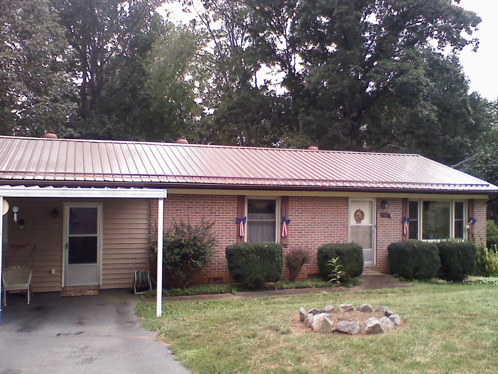 Bronze metal roof and carport on a brick ranch home — Roof Repair work by our crew in Waco